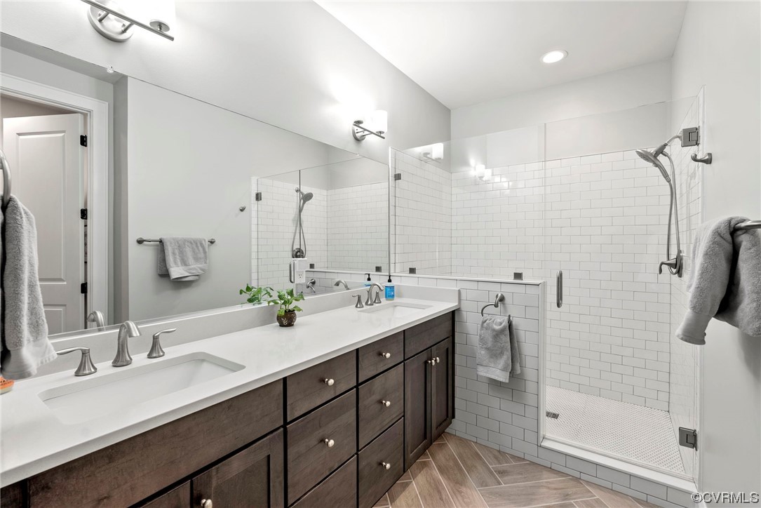 En suite bath with walk-in tile shower and dual vanities.