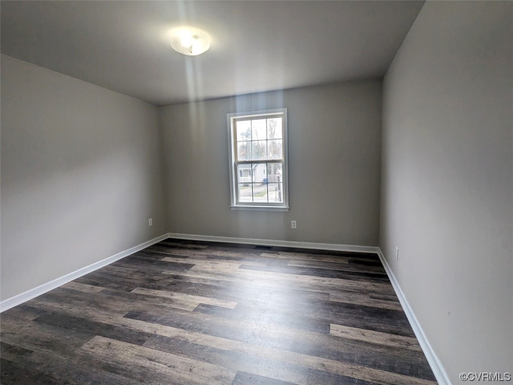 Unfurnished room featuring dark hardwood / wood-style flooring