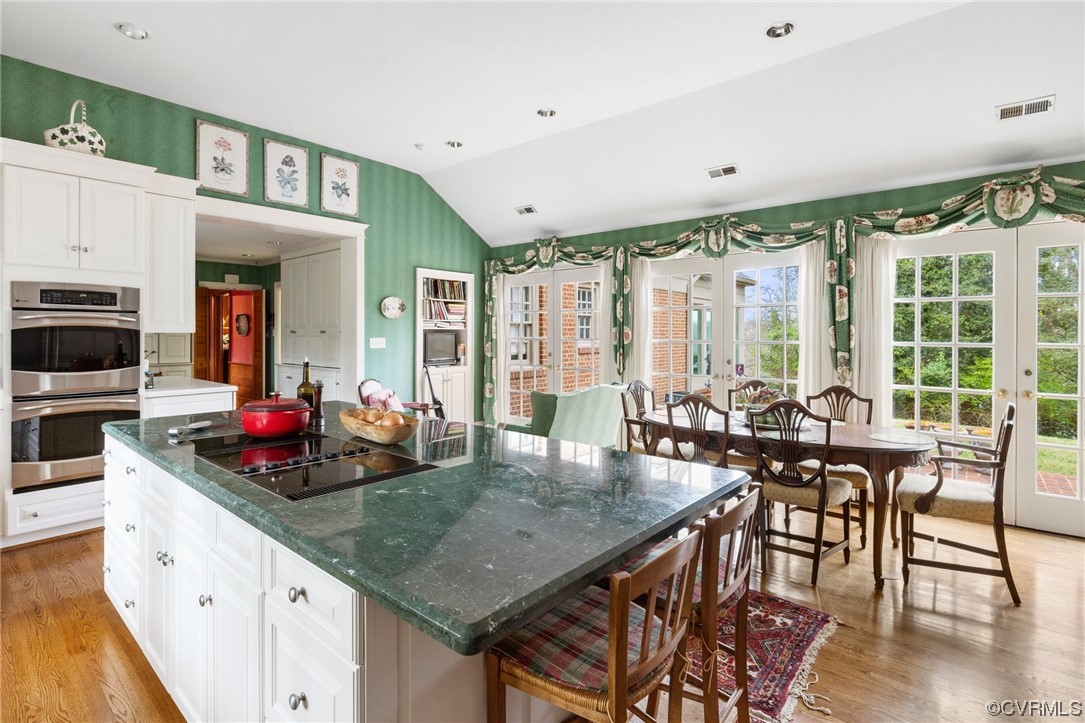 Stainless steel wall ovens, sitting area & French doors to a terrace w/ views of the James River