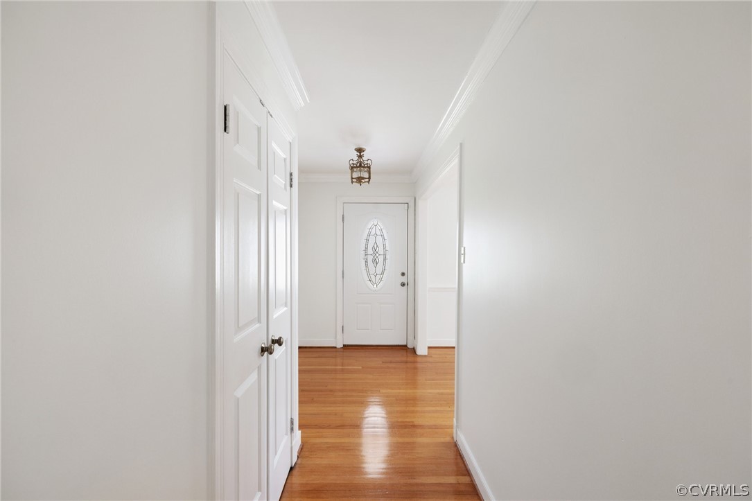 Corridor featuring crown molding and light wood-type flooring