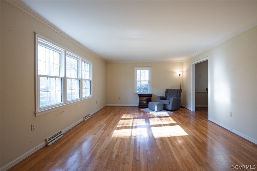 Empty room featuring dark hardwood / wood-style floors and ornamental molding