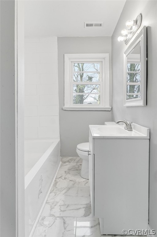 Full bathroom featuring vanity, toilet, tile flooring, and a healthy amount of sunlight