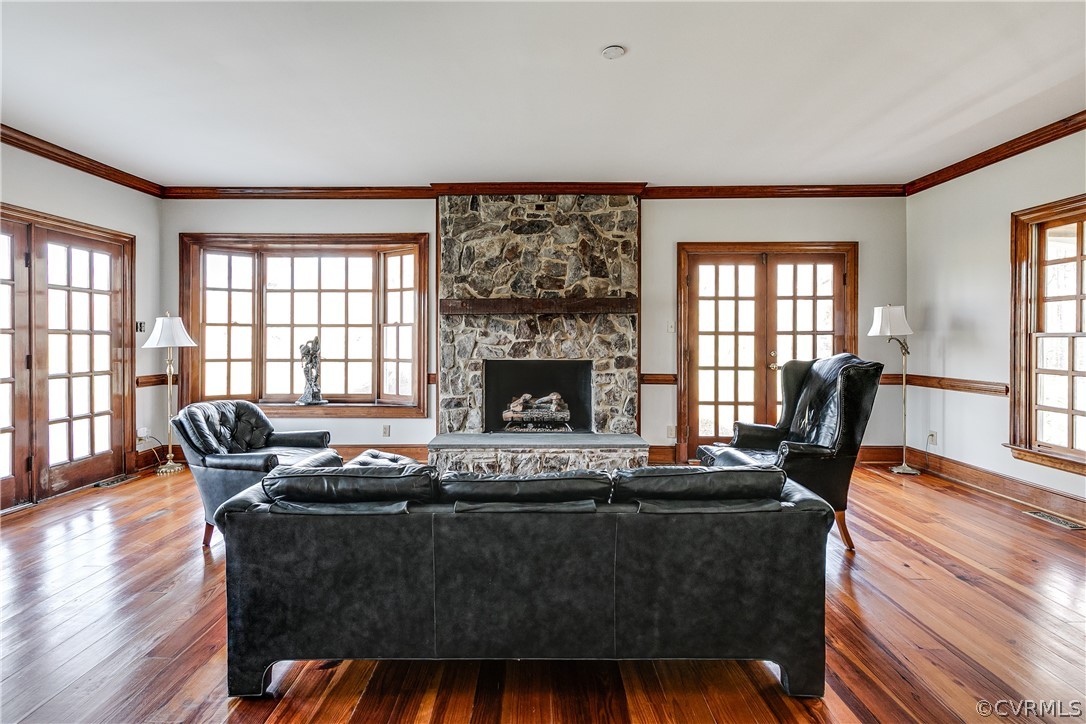 Gas fireplace has beautiful stone surround. French doors on the right lead to a circular brick exterior staircase.