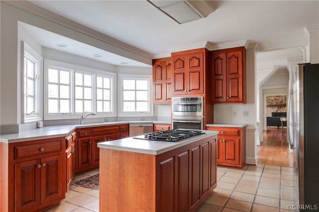 Kitchen has ceramic tile flooring, island with gas cooking, and cherry cabinetry.