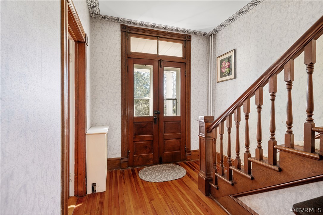 Foyer featuring dark ornamental molding, hard wood floors and French doors