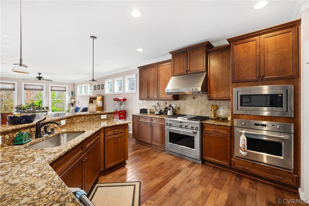 Kitchen featuring sink, ceiling fan, wood-type flooring, and stainless steel appliances