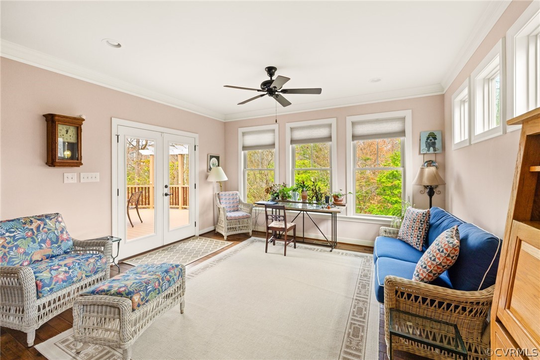 Sitting room featuring french doors, light wood-type flooring, ceiling fan, and ornamental molding