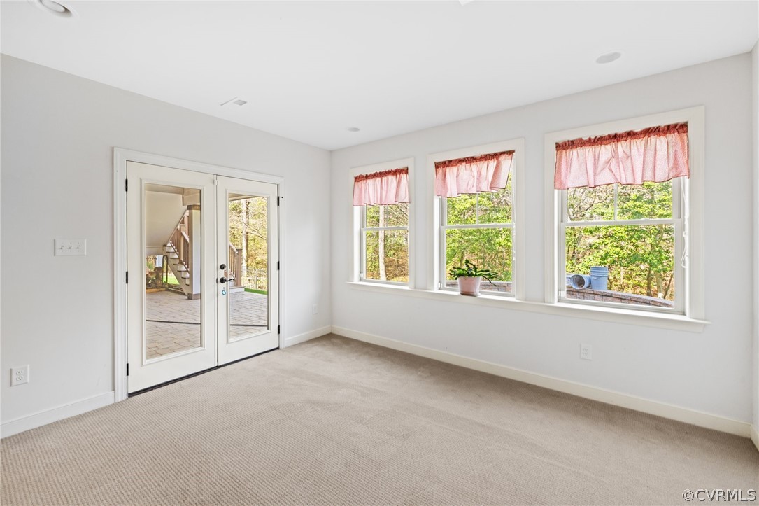 Carpeted empty room featuring french doors