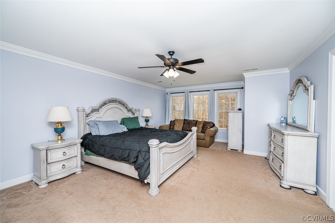 Carpeted bedroom featuring crown molding and ceiling fan