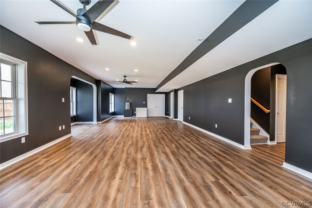 Unfurnished living room with dark wood-type flooring and ceiling fan