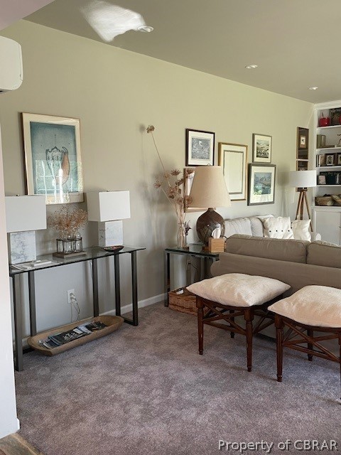 Carpeted living room featuring a wall unit AC