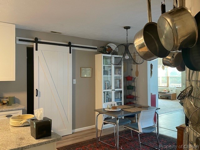 Dining room featuring light hardwood / wood-style flooring and a barn door