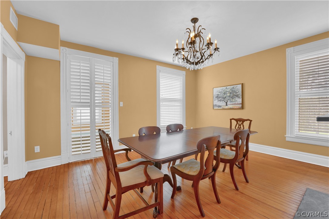 Dining room featuring an inviting chandelier and light hardwood / wood-style flooring