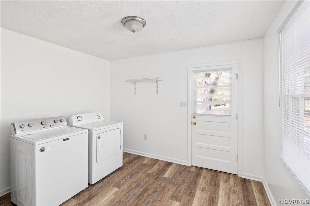 Laundry room featuring hardwood / wood-style flooring and washer and clothes dryer