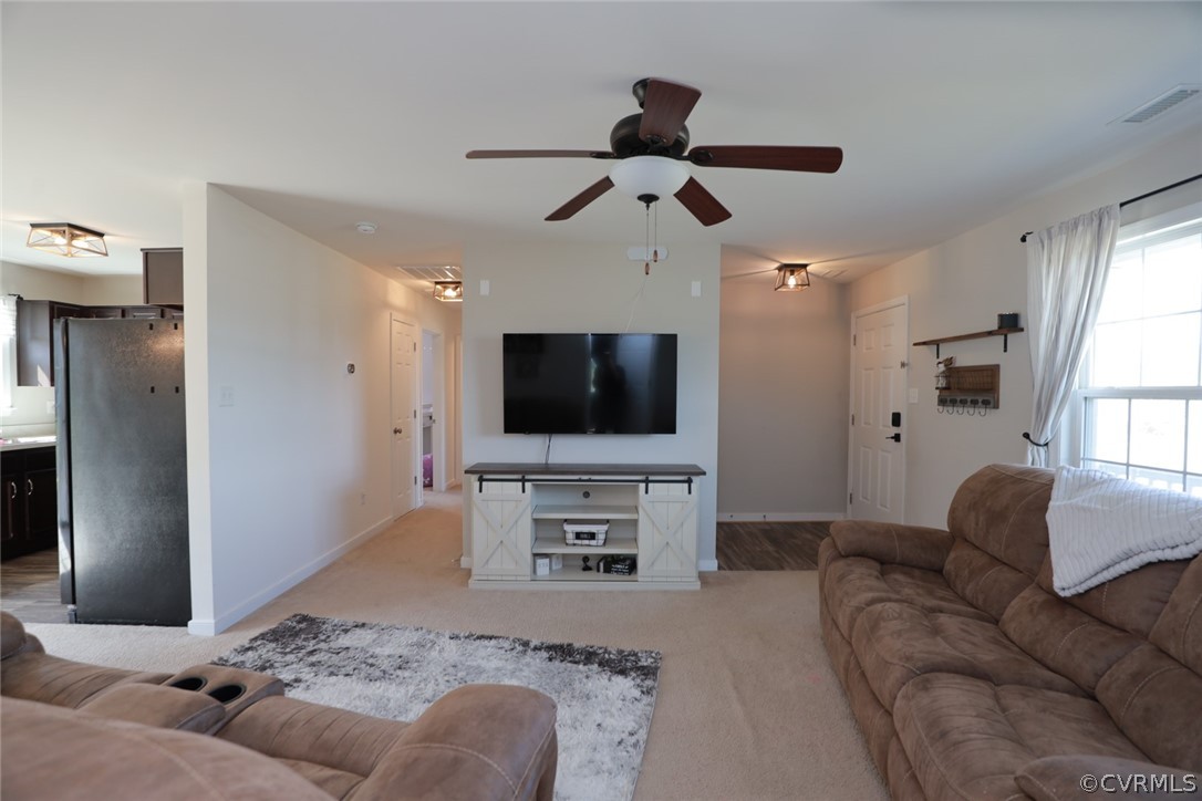 Living room with light vinyl flooring and ceiling fan