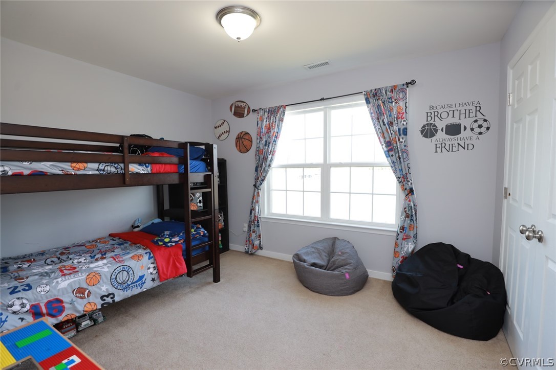 Bedroom #2 with multiple windows and light colored carpet