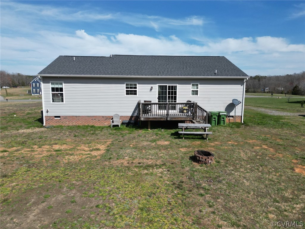 Rear view of property with a lawn and a wooden deck