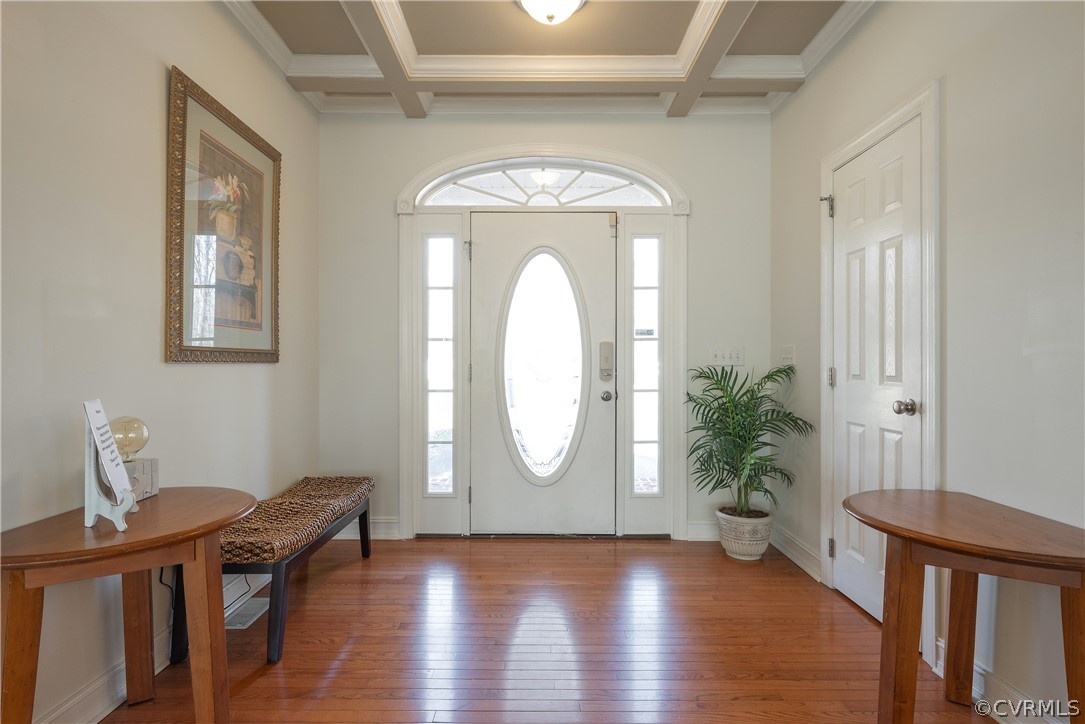 Entryway with beam ceiling, coffered ceiling, and hardwood / wood-style flooring