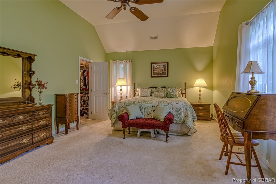 Primary bedroom with high vaulted ceiling and a spacious walk-in closet