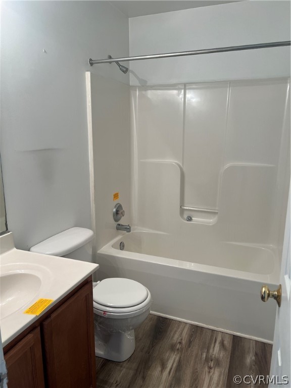 Full bathroom with hardwood / wood-style floors, vanity, toilet, and tub / shower combination