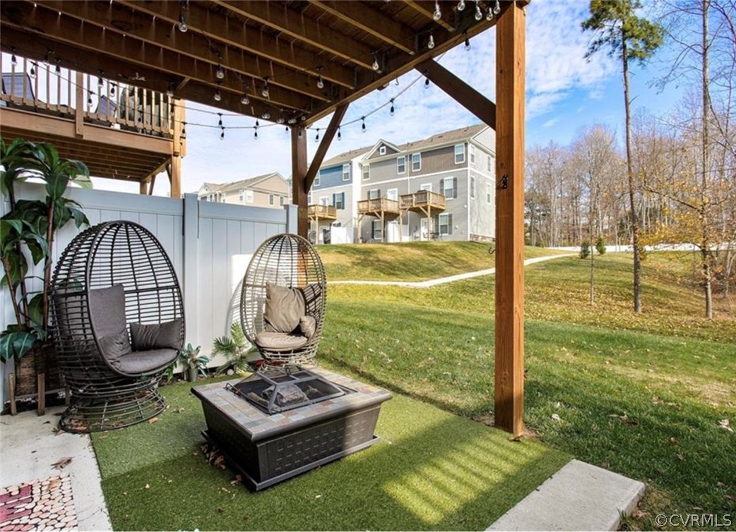 View of yard featuring a balcony and a fire pit