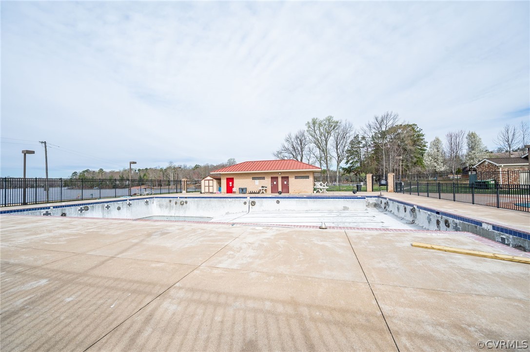View of swimming pool featuring a patio at the lakefront