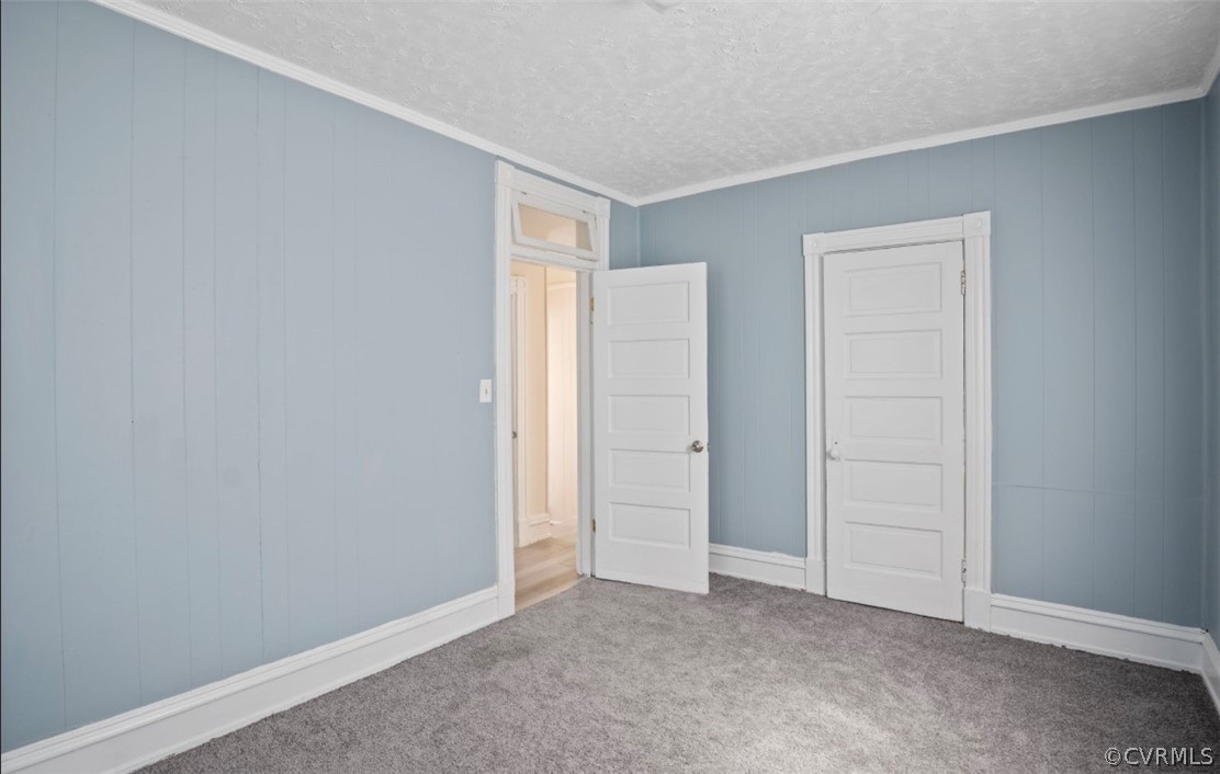Unfurnished bedroom with carpet flooring, crown molding, and a textured ceiling