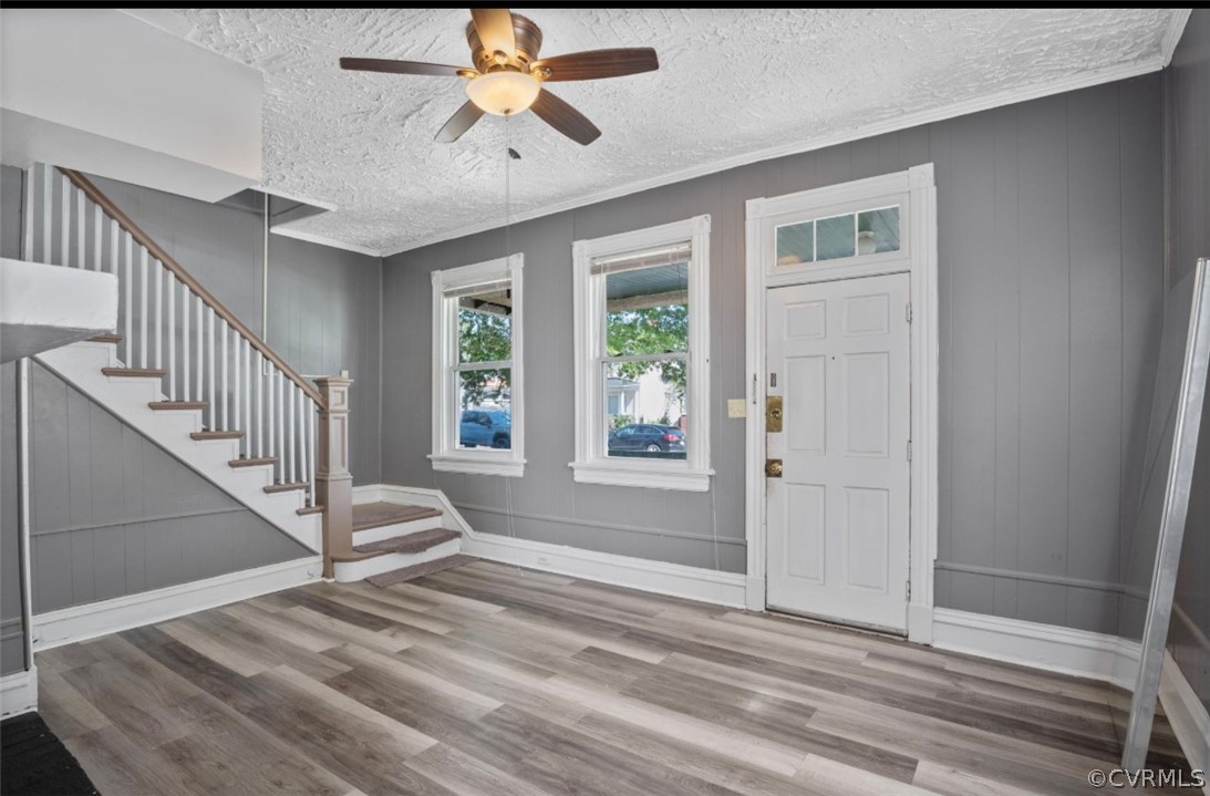 Entrance foyer featuring a textured ceiling, ceiling fan, and hardwood / wood-style flooring