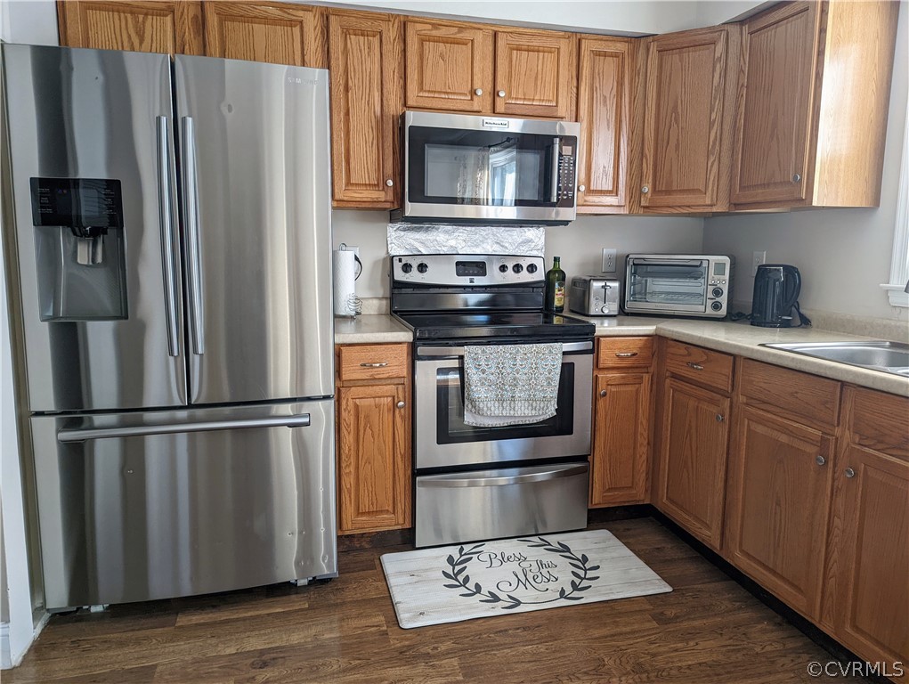 Kitchen featuring appliances with stainless steel finishes and dark hardwood / wood-style floors