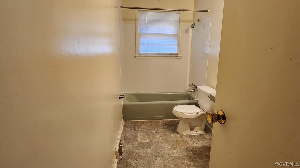 Bathroom with toilet, tile floors, and tub / shower combination