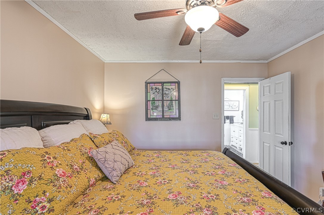 Bedroom featuring ornamental molding, a textured ceiling, and ceiling fan
