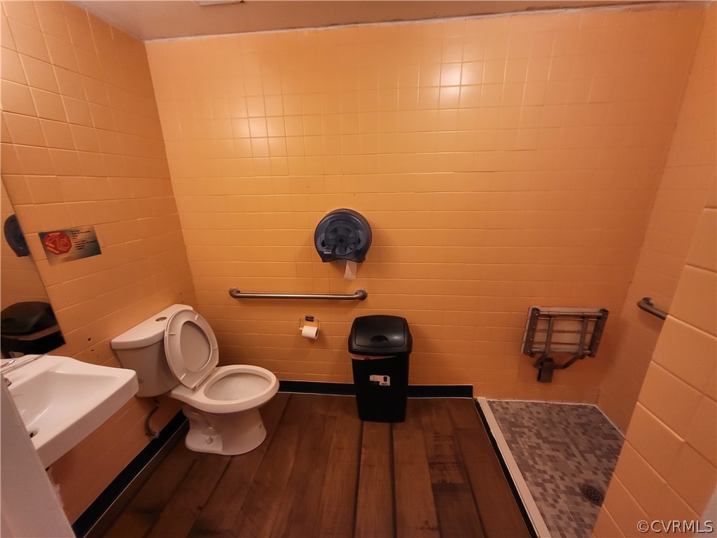 Bathroom featuring toilet, hardwood / wood-style floors, a shower, and sink