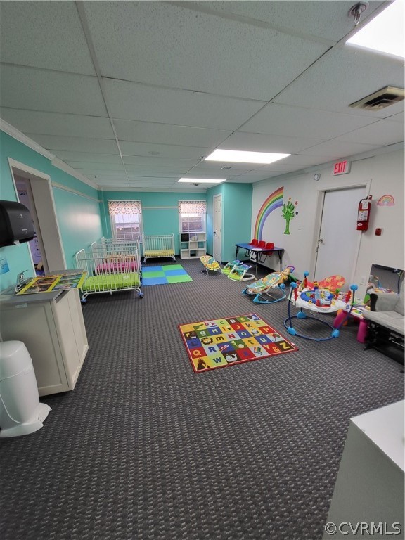 Playroom with a paneled ceiling and dark carpet