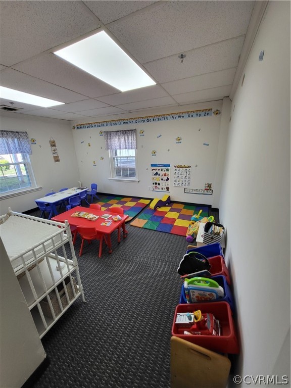 Playroom with a paneled ceiling and carpet floors
