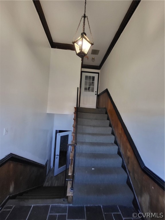 Staircase featuring crown molding