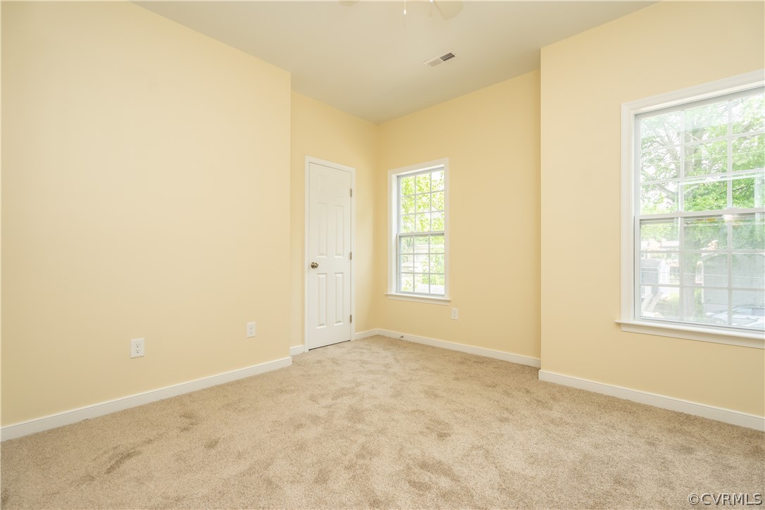 Unfurnished room featuring light carpet and a healthy amount of sunlight