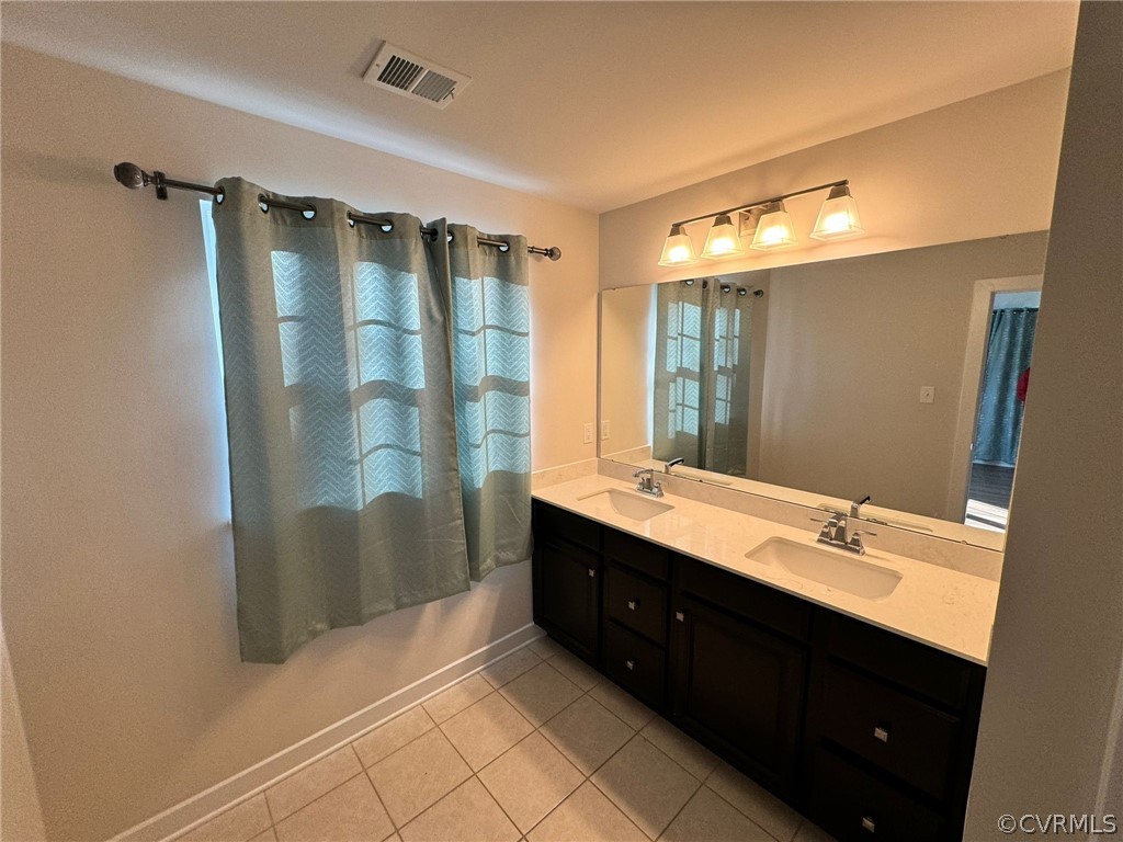 Bathroom featuring tile floors, double sink, and oversized vanity