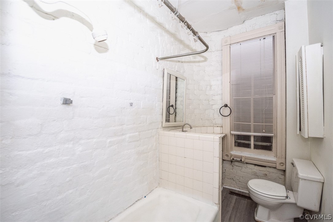 Bathroom featuring tiled shower / bath and toilet