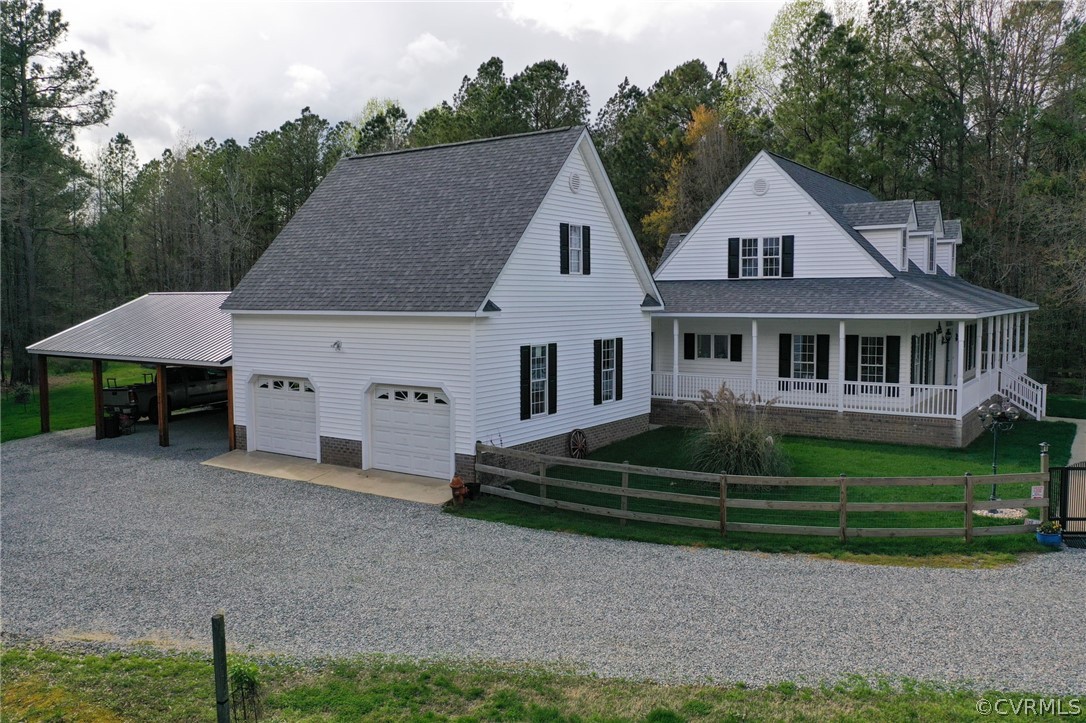 View of front of house with a porch, a carport, a front lawn, and a garage