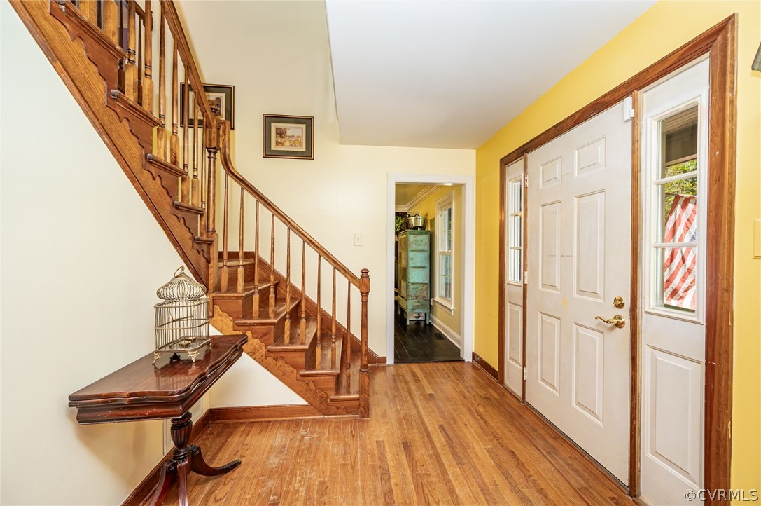 Foyer with hardwood / wood-style floors and ceiling fan