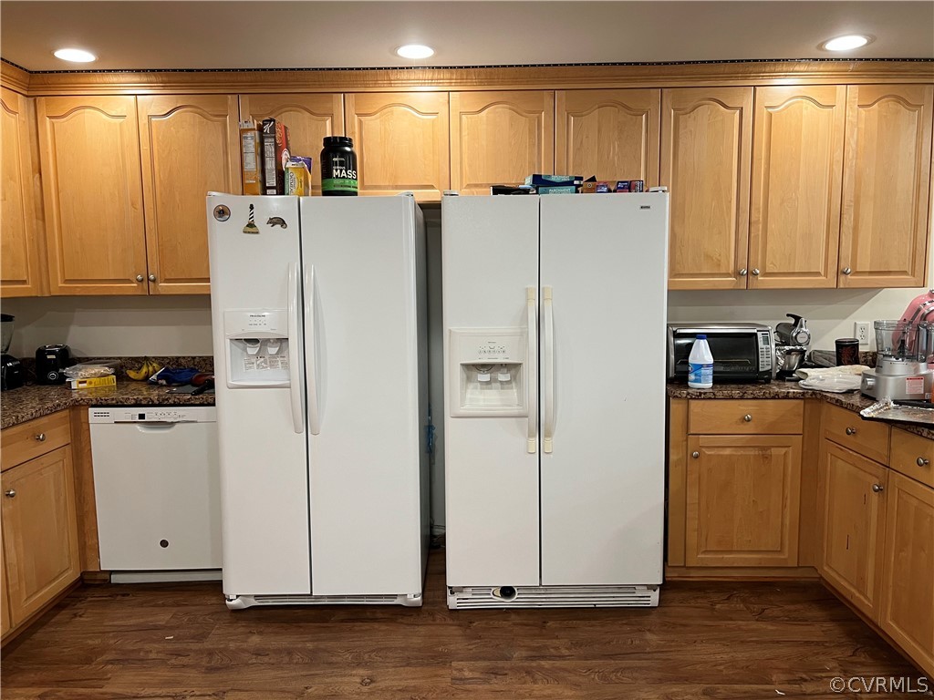 Kitchen featuring white appliances, dark hardwood / wood-style flooring, and dark stone counters