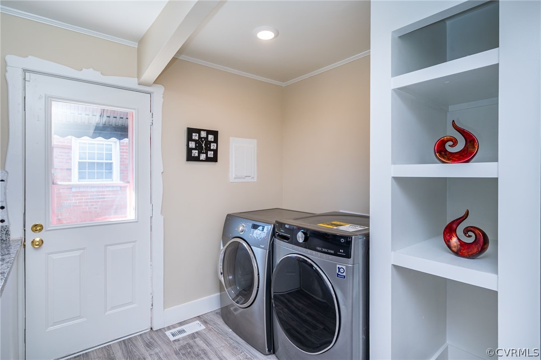 Laundry area with independent washer and dryer and light wood-type flooring