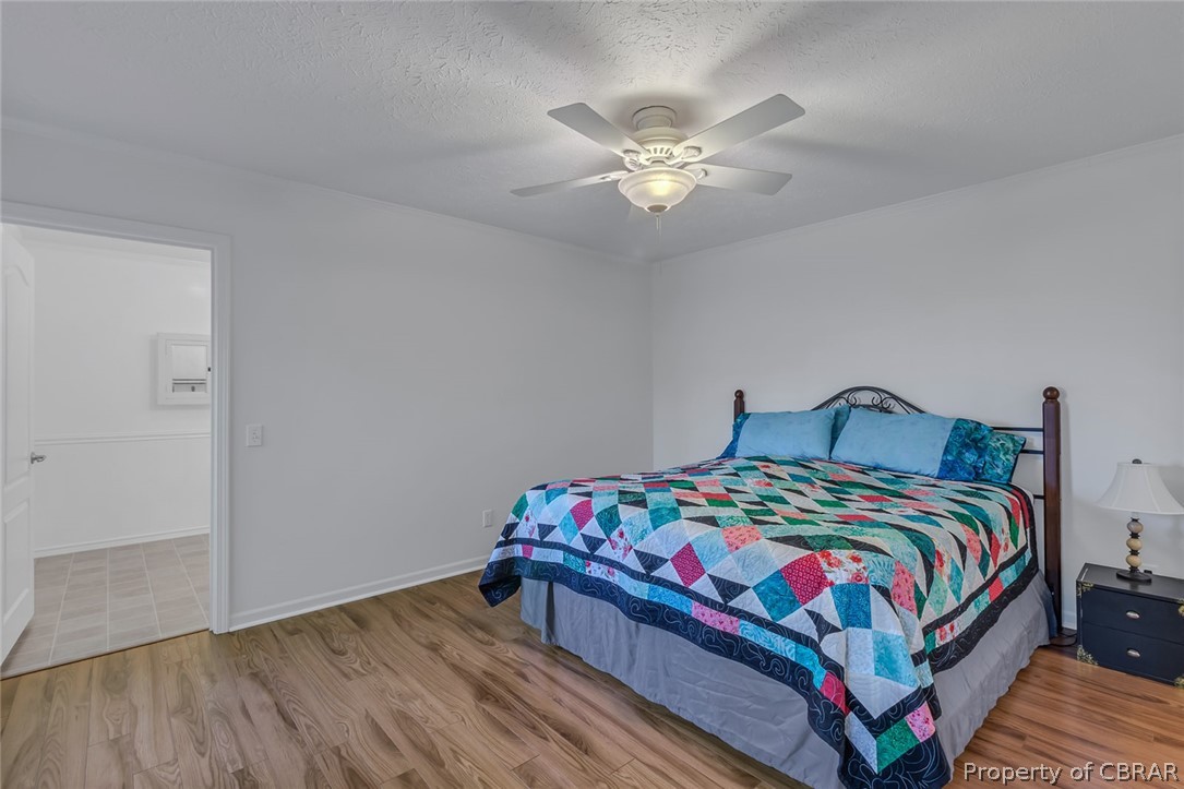Bedroom with a textured ceiling, ceiling fan, and light tile flooring