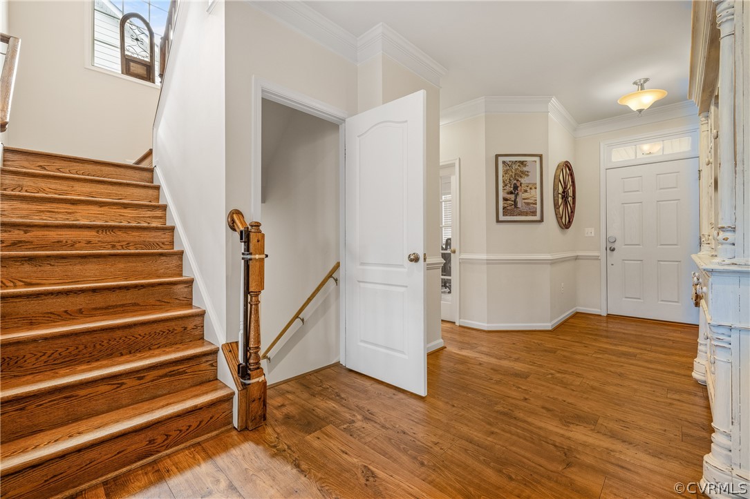Entryway with crown molding and light wood-type flooring
