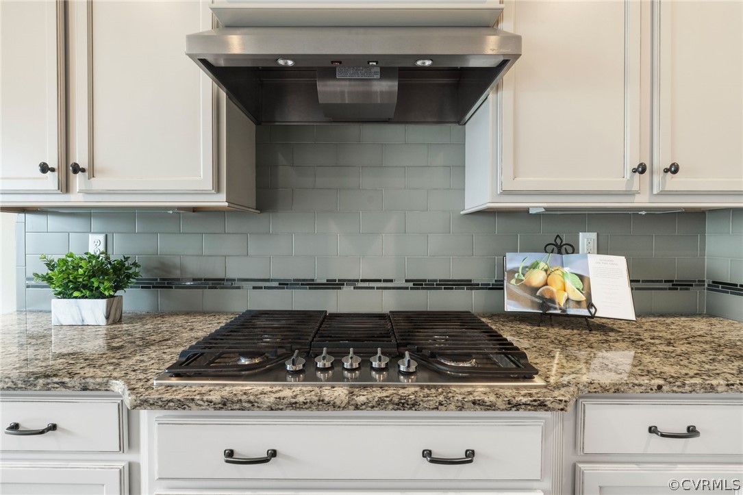 Gourmet Kitchen features include a gas cooktop, vented hood, wall oven & microwave, custom cabinetry with pots and pans drawers, granite countertops and under cabinet, recessed & pendant lighting.