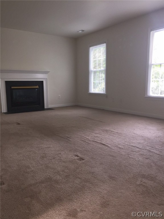 Unfurnished living room featuring carpet