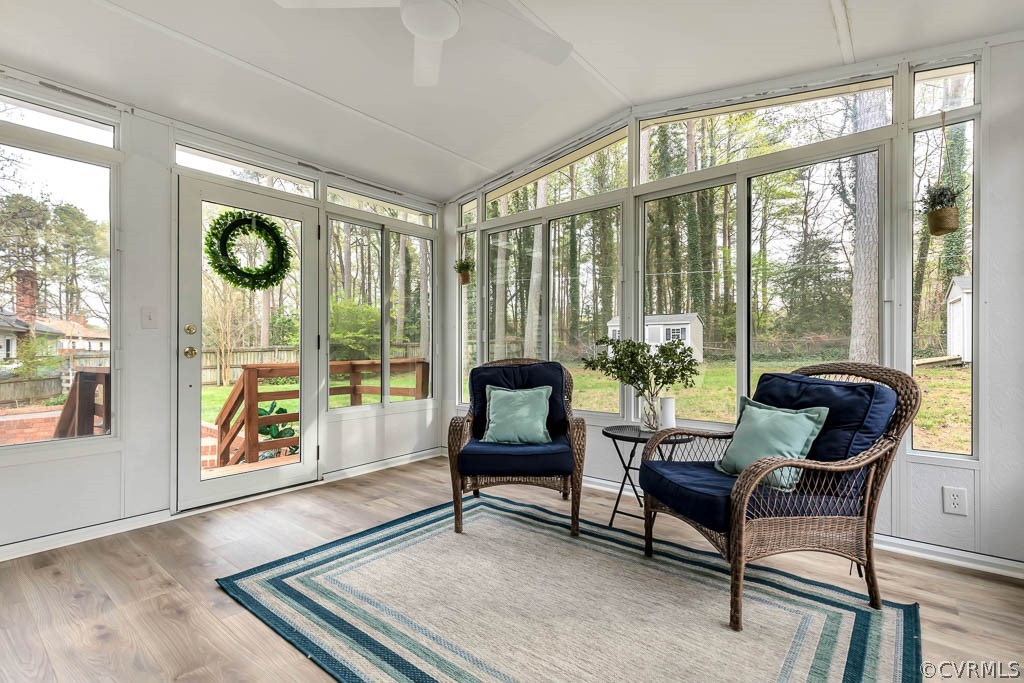 Sunroom / solarium featuring ceiling fan and vaulted ceiling