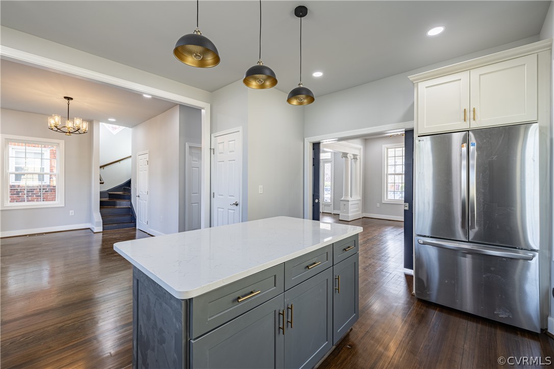 Kitchen featuring stainless steel fridge, a healthy amount of sunlight, white cabinets, and dark hardwood / wood-style floors