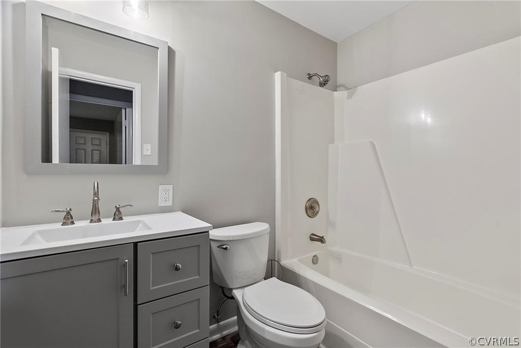 Full bathroom with toilet, vanity, and bathing tub / shower combination
