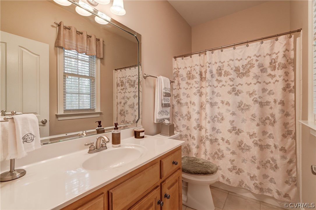 Bathroom connected to 2nd Bedroom featuring tile flooring, vanity with extensive cabinet space, and toilet